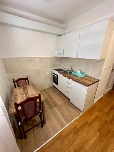 una pequeña cocina con mesa y fregadero en Apartment Stex 2, en Podgorica