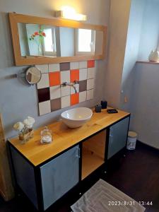 a bathroom with a counter with a sink and a mirror at Appartement Maison Vosgienne La Bresse Centre in La Bresse