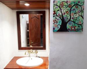a bathroom with a sink and a painting on the wall at Casita rural Molino de La Corte in Antigua +9 photos