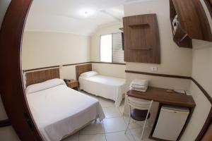 een ziekenhuiskamer met 2 bedden en een bureau bij HOTEL MILANO in Sorocaba