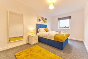 a bedroom with a blue bed and a mirror at The Norham - Properties Unique in North Shields