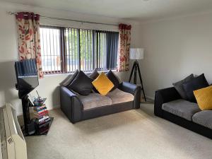 a living room with a couch and a tv at Spencer Court in Hornchurch