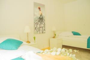 a bedroom with two beds and a painting on the wall at Wellnessoase mitten in der Wasserfallstadt Triberg in Triberg