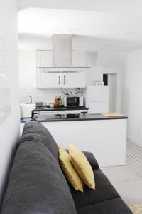 a couch with two yellow pillows in a kitchen at Casa das Nobres in Évora