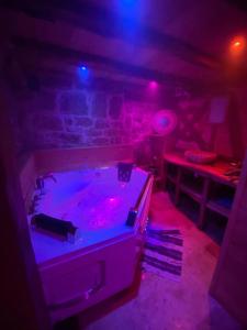 Habitación con bañera de hidromasaje con luces púrpuras. en Cassiopée, en Figeac