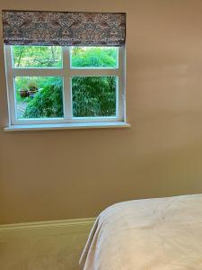 - une chambre avec un lit et une fenêtre dans l'établissement The Grannery, à Wadhurst