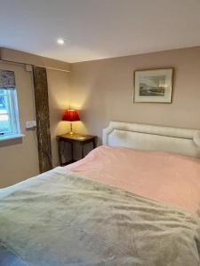 a bedroom with a bed and a lamp on a table at The Grannery in Wadhurst