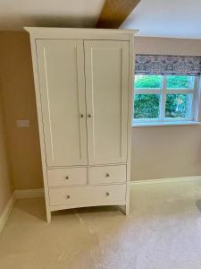 a white cabinet in a room with a window at The Grannery in Wadhurst