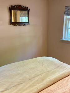 - une chambre avec un lit et un miroir mural dans l'établissement The Grannery, à Wadhurst