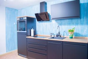 uma cozinha azul com um lavatório e um frigorífico em Wellnessoase mitten in der Wasserfallstadt Triberg em Triberg