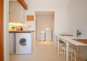 a kitchen with a washing machine and a counter at The Lavendrye in Wadhurst