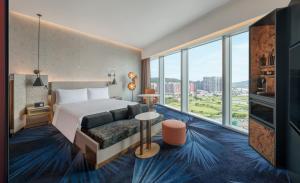 a hotel room with a bed and a large window at W Macau - Studio City in Macau