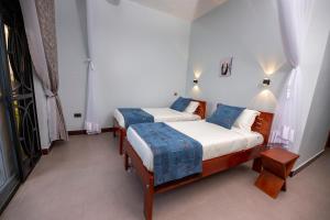 1 Schlafzimmer mit 2 Betten in einem Zimmer in der Unterkunft The Kraal in Mbarara