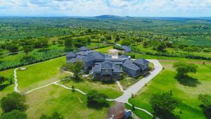 une vue aérienne sur une grande maison sur un champ verdoyant dans l'établissement The Kraal, à Mbarara