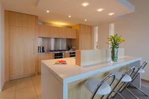a kitchen with a island with chairs and a counter top at Lake View Villa, Great location and Amazing views in Queenstown
