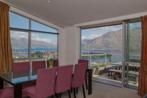 a dining room with a table and chairs and a large window at Lake View Villa, Great location and Amazing views in Queenstown