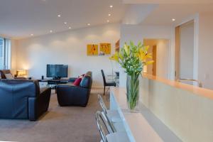 a living room with a vase of flowers on a table at Lake View Villa, Great location and Amazing views in Queenstown