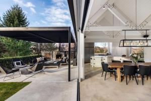 an open kitchen and dining room with a table and chairs at Arrow Wood - Minutes to Arrowtown, Golf and Wineries - Luxury Living in Arrowtown