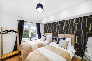 Duas camas num quarto com um mural de parede em Exquisite London Home - Parking - Sleeps 10 em Dagenham