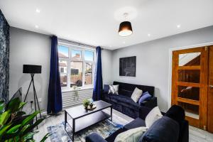 a living room with a couch and a table at Exquisite London Home - Parking - Sleeps 10 in Dagenham