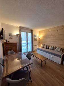ein Wohnzimmer mit einem Bett und einem Tisch in der Unterkunft Studio Les 3 Lys Auron in Auron