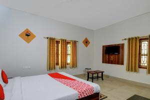 a bedroom with a bed and a tv and windows at OYO Flagship Hotel Anvi in Bhubaneshwar