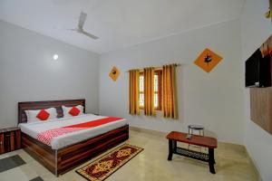 a bedroom with a bed and a table in it at OYO Flagship Hotel Anvi in Bhubaneshwar