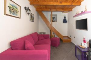 a living room with a purple couch and a tv at Stone houses Nikola in Podorljak