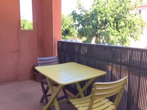 - Balcón con mesa de madera y 2 sillas en Calme pour cet appartement 4 personnes - résidence Piscine - parking privé - 4HAMCL2A, en Claira