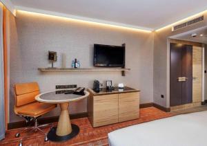 a hotel room with a table and a tv at Hilton London Tower Bridge in London