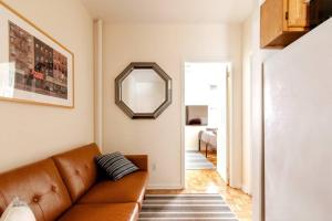 ein Wohnzimmer mit einem braunen Sofa und einem Spiegel in der Unterkunft ✪ Large 2 Bedrooms ✪ Queen Beds ✪ Work Stations in New York