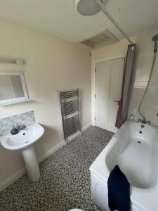 a bathroom with a sink and a tub and a toilet at Dundonagh House, Glaslough, in Monaghan