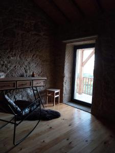 a room with a table and a chair and a window at Gardunha Stone in Louriçal do Campo
