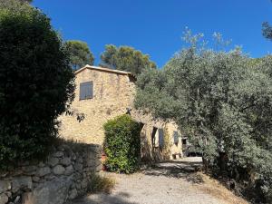 an old stone house with trees and a stone wall at Véritable Bastidon Provençale in Le Tholonet