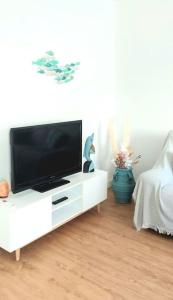 a flat screen tv sitting on a white entertainment center at La puerta al Mar in Calafell