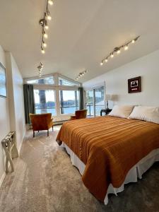 a large bedroom with a large bed and windows at The Main Deck Cliffside Ocean Views in Kodiak