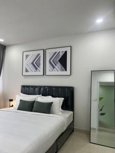 a bedroom with a large bed with two pictures on the wall at ImPian 1BR homestay in Phnom Penh