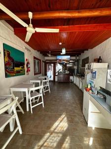 ein Esszimmer mit Tischen und einem Deckenventilator in der Unterkunft Posada Costa del Sol in Colón