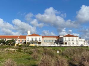 ein großes Gebäude mit einem Uhrturm im Hintergrund in der Unterkunft Villa in Praia D'el Rey, Beach & Golf Resort in Casal da Lagoa Seca