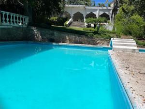 una gran piscina azul frente a una casa en Teques inn, en Tequesquitengo