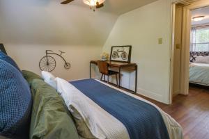 Un dormitorio con una cama y un escritorio con una bicicleta en la pared en Springfield Home with Yard 3 Mi to Downtown! en Springfield