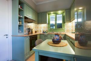 una cucina con armadi verdi e un tavolo con ciotola di Thalia Kassiopi Apartment a Kassiopi