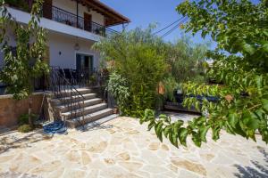 una casa con una scala davanti a un cortile di Thalia Kassiopi Apartment a Kassiopi
