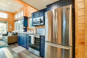 a kitchen with blue cabinets and a stainless steel refrigerator at Tree-Lined Whitney Cabin about 11 Mi to Lake Whitney! in Whitney