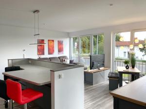 eine offene Küche und ein Wohnzimmer mit einem roten Stuhl in der Unterkunft Ferienappartement Balve in Sassnitz