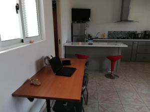 una cocina con mesa de madera y ordenador portátil. en Casa Yô en Mindelo
