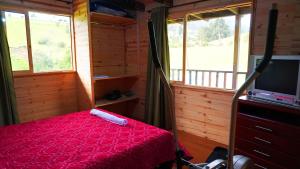 a bedroom with a bed and a tv and windows at Finca Severo Refugio in Zipaquirá