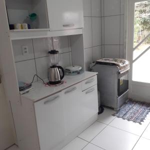 uma pequena cozinha branca com um liquidificador no balcão em Casa# Cantinho do Sossego em São Francisco do Sul