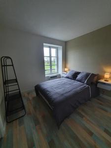 a bedroom with a bed and a ladder and a window at Le bien être aux forges in Céaux