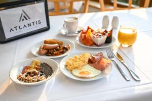 ブルノにあるホテル アトランティスの朝食用の食品とドリンクの盛り合わせが備わるテーブル